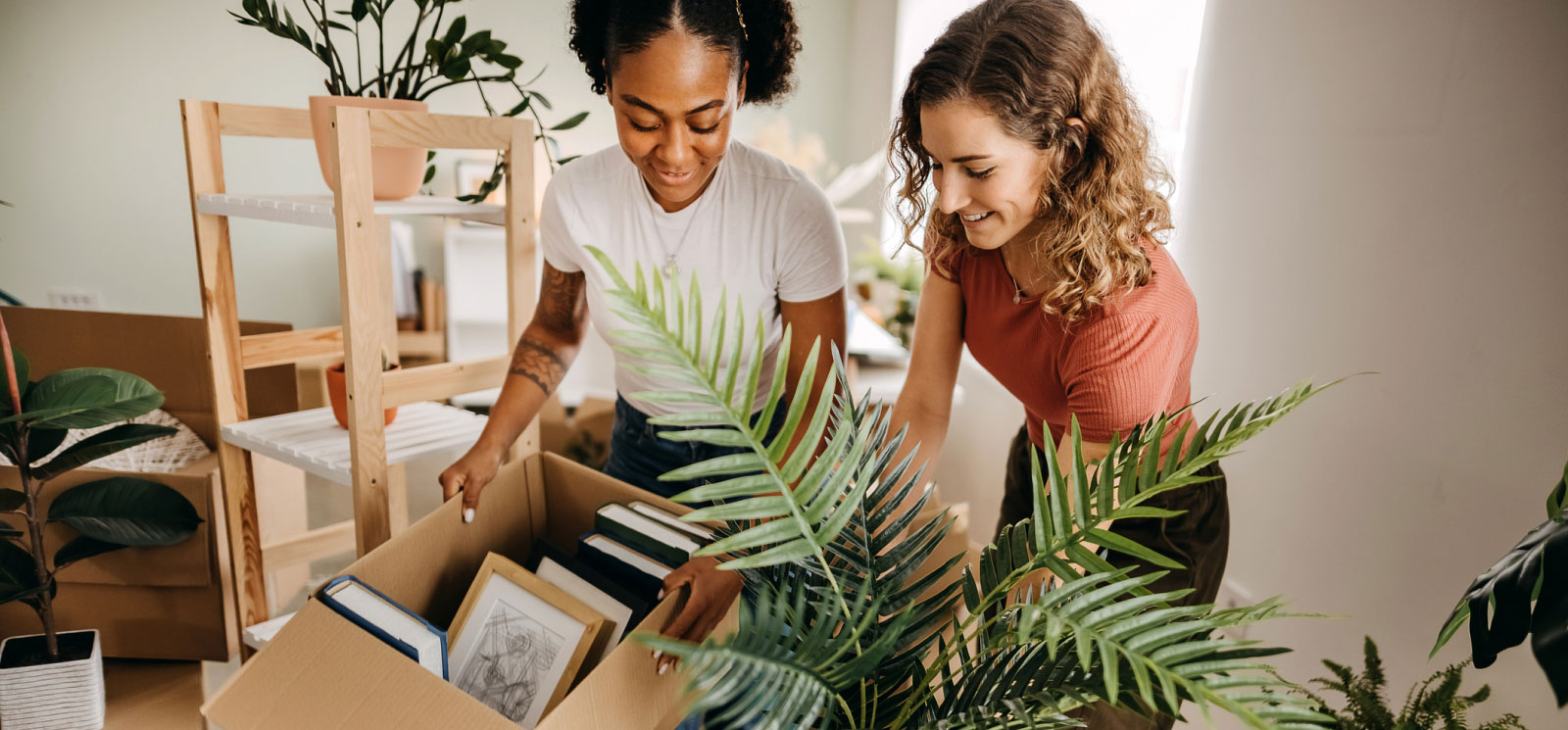 two young women unpacking moving boxes