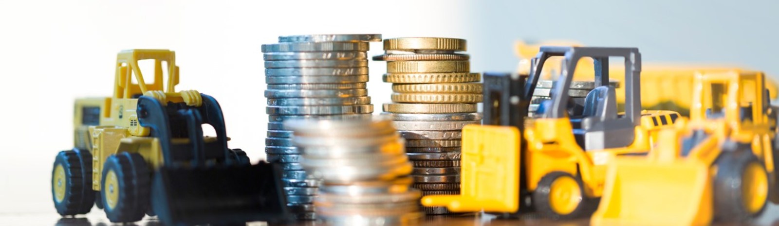 toy constructions vehicle next to a stack of coins